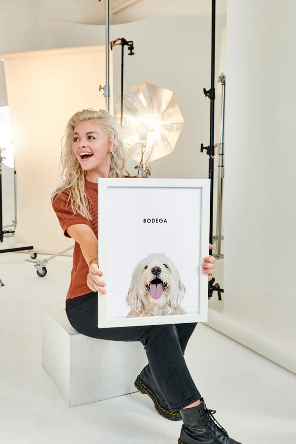 Cliente tenant le portrait personnalisé de son chien, dessiné à la main